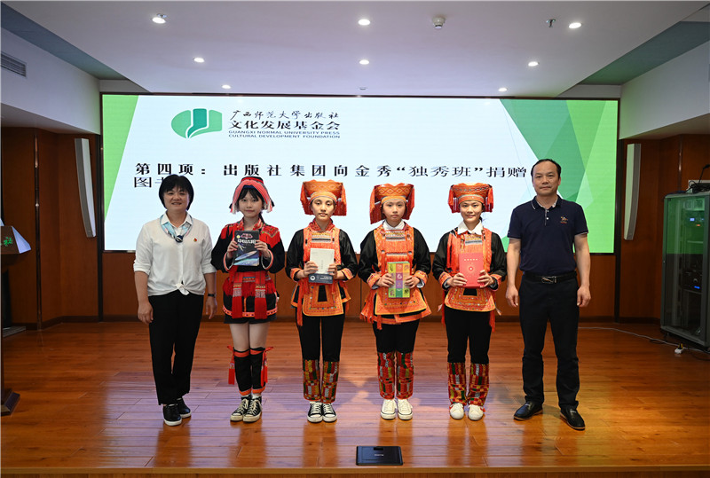 廣西師范大學(xué)出版社集團副總裁、工會(huì )主席莫曲波（右一）代表出版社向金秀“獨秀班”同學(xué)贈送圖書(shū)（李顯楊攝）.jpg